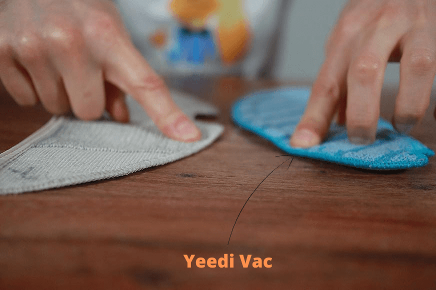 Das Wischuch des Yeedi Vac Saug-Wisch-Roboters liegt auf dem Tisch neben einem qualitativ minderwertigen WIschtuch.